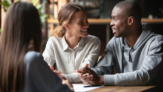 Young-couple-reviewing-house-hunting-checklist-with-real-estate-agent.png
